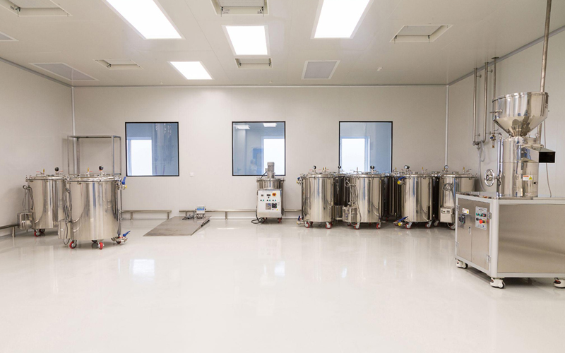 Interior of Chemo Biopharmaceutical processing facility with hygienic wall panels and stainless steel equipment, illustrating a cleanroom environment.